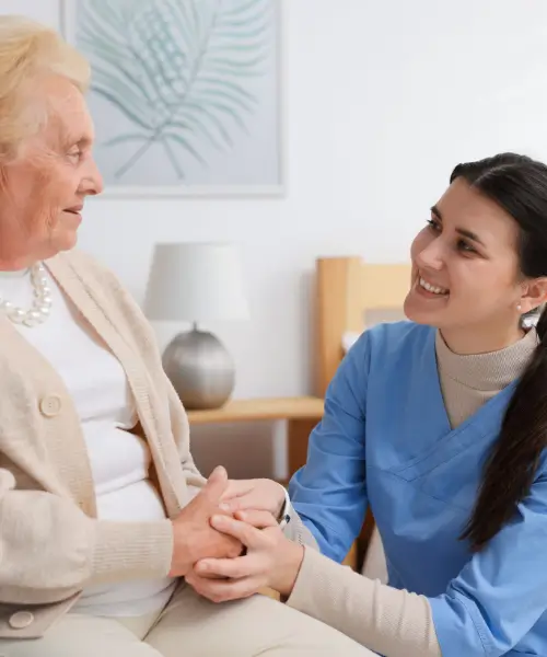 young-female-carer-wearing-blue-uniform-holding-female-patient-hand.